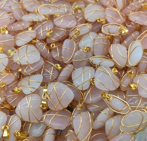 Macro shot of rose quartz heart pendants with golden wire wrap craftsmanship