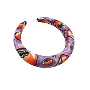 Padded football patterned headband in purple, orange, and black on a white background