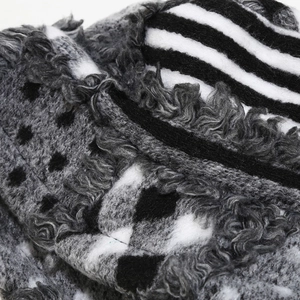 Macro shot of fuzzy bucket hat with black polka dots, stripes, and faux fur trim detail