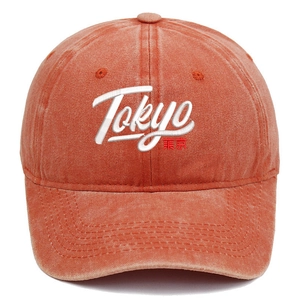 Detailed embroidery of Tokyo text on a vintage washed brick red cotton baseball cap