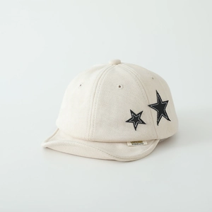 Detail of beige suede kids baseball cap with star patches and soft stitching texture