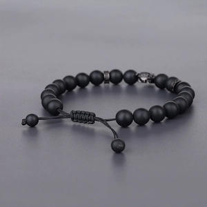 Detailed close-up of a black leopard bead bracelet with adjustable woven strap