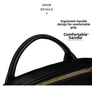 Detail of black pebbled leather backpack with rounded handle and gold metal zipper