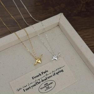 Detailed close-up of heart-shaped planet pendants in gold and silver finish on linen