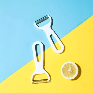 Set of two Japanese style stainless steel vegetable peelers with white ergonomic handles