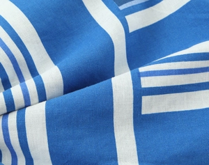 Detailed macro view of the blue and white striped linen fabric with soft draped texture