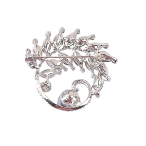 Back view of silver royal green crystal brooch showing the pin mechanism and metal texture