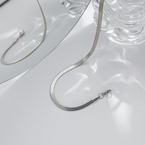 Detailed view of silver flat snake chain necklaces with lobster clasp and wave reflections