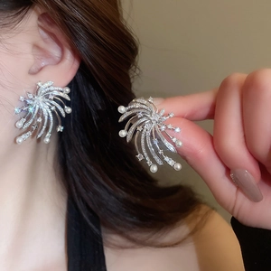Detail view of silver fireworks stud earrings with sparkling rhinestones and white pearls