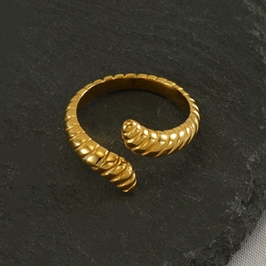 Bague torsadée ajustable en acier inoxydable doré sur fond de pierre grise