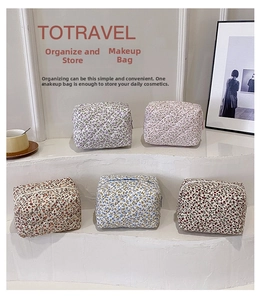 Detail of five floral quilted cotton makeup bags in various colors on a white display