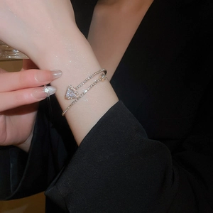 Close-up of golden square open cuff bracelet featuring zircon inlay and triangle cut stone