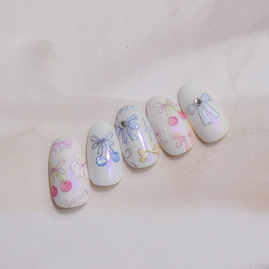 Detail of aurora pearl nail stickers with pink and blue bows and cherry patterns