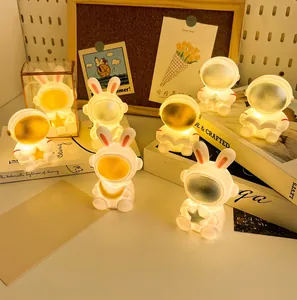 Close-up of astronaut and bunny night lights emitting warm yellow glow in a gift set