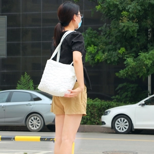 Detailed view of the white quilted texture and soft fabric on a large tote bag