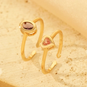 Close-up of adjustable gold rings with purple oval and pink heart-shaped zircons