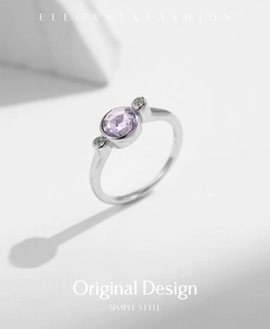 Gros plan d'une bague en argent S925 avec pierre violette ronde et ombres géométriques blanches