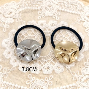 Detail view of gold and silver metal pony cuff hair ties with 3.8cm irregular textured disc