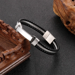 Macro shot of men's leather and steel cable bracelet with magnetic clasp on wood