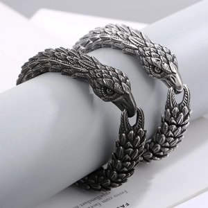 Macro shot of punk eagle head bracelets with detailed feather texture in antique silver finish