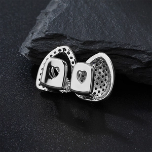 Detailed macro view of silver hip hop grillz with heart cutout and zircon micro-paving