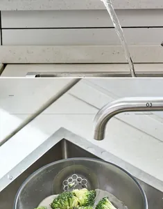 Close-up of stainless steel colander basket filtering fresh broccoli in kitchen sink