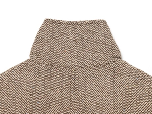 Dettaglio del colletto della giacca in tweed marrone a spina di pesce con fibre