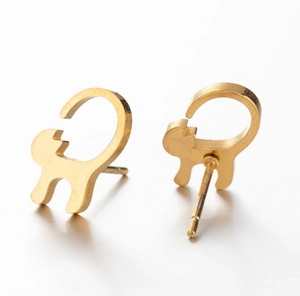 Detailed view of golden cat silhouette stud earrings with brushed metal finish texture