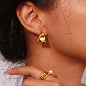 Minimalist gold wrinkled earrings and pearl ring set on model showing trendy style