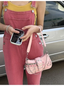 Pink Y2K shoulder bag with star rivets and metal chain detail shown on a model
