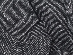 Macro shot of high-quality black and white herringbone tweed fabric texture with soft folds