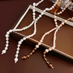 Elegant multi-color pearl necklace with sparkling rhinestone bow pendant detail