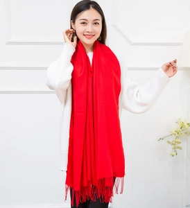 Close-up of bright red cashmere-feel scarf featuring dense fringe tassels and soft texture