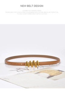 Detail of a thin brown leather belt with a wavy gold buckle on an open magazine