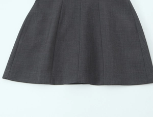 Detail shot of a dark grey dress showing multi-panel cut and high-quality woven fabric seams