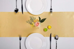 Detailed top view of champagne gold satin table runner with elegant place settings