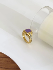 Detail of vintage gold signet ring with purple square enamel and side zircon accents