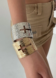 Detail of hammered metal cuff bracelets with hollow cross design in gold and silver finish