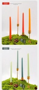 Detalle de velas cónicas de 10 pulgadas en naranja y verde sobre soportes dorados