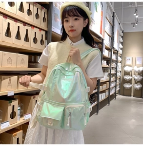 Close-up of laser holographic green backpack with multiple utility pockets and buckles