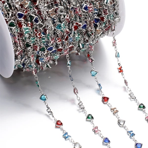 Macro shot of colorful crystal heart and butterfly charms on silver DIY jewelry chain