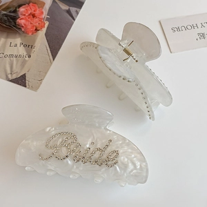 Elegant pearl white acetate hair claw clips with marble texture and Bride rhinestone detail