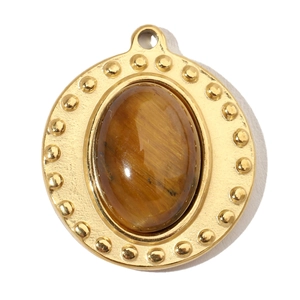 Macro shot of oval gold-plated pendant with natural brown tiger eye stone inlay
