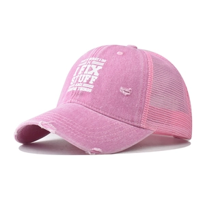 Dettaglio del cappello trucker rosa effetto consumato con stampa I Fix Stuff e rete