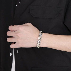 Men's two-tone gold and silver link bracelet with square zirconia on black shirt
