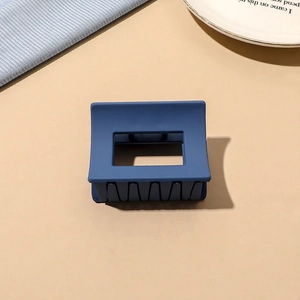 Close-up of matte navy blue square hair claw clip with minimalist hollow geometry design