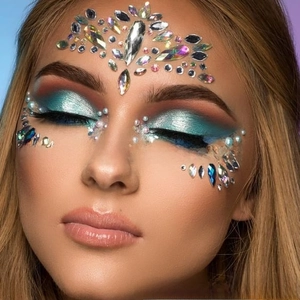 Macro shot of AB iridescent rhinestones and pearls face stickers for festival makeup