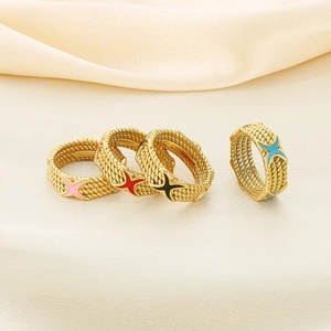 Close-up of gold stainless steel rings with colorful X-shaped enamel on satin