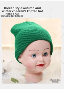 Close-up of the fine knit texture and green warm fabric of the autumn winter kids beanie