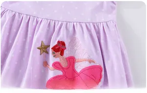 Détail d'une robe lilas à pois avec broderie de fée et baguette magique en gros plan